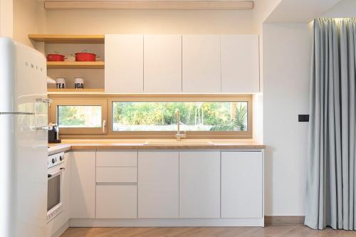 a white kitchen with a sink and a window at White Nest Villas in Litochoro