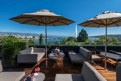 a patio with chairs and umbrellas with a view at Hôtel Métropole Genève in Geneva