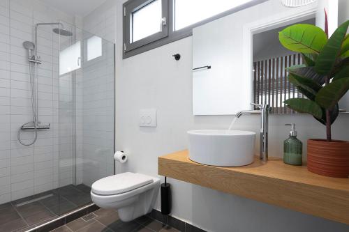 a white bathroom with a sink and a toilet at White Nest Villas in Litochoro