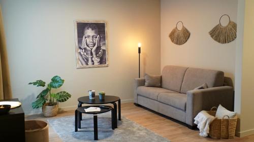 a living room with a couch and a table at Bloomhotel in Lochristi
