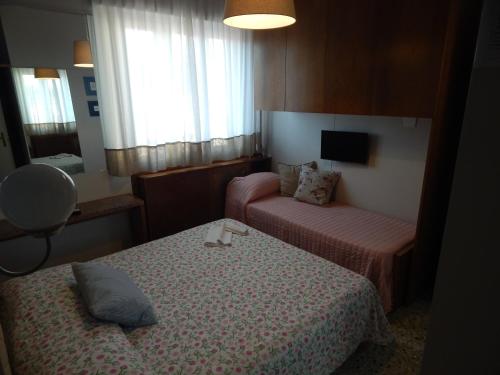 a hotel room with two beds and a tv at Hotel Ristorante La Terrazza in Lido di Camaiore