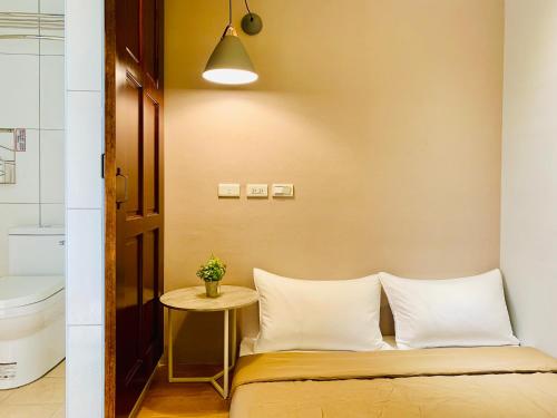 a small bedroom with a bed and a table at OYAJI Guesthouse 歐野基民家宿泊 in Tainan