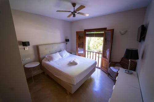 a bedroom with a white bed and a window at Villa Tegui is a luxury villa close to San Rafael and 10 min drive to Ibiza Town and San Antonio in Ibiza Town