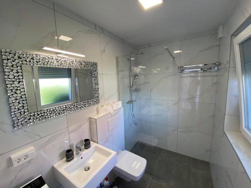 y baño blanco con lavabo y ducha. en Villa Lara Terme Čatež 6 Thermal Riviera Tickets, en Čatež ob Savi