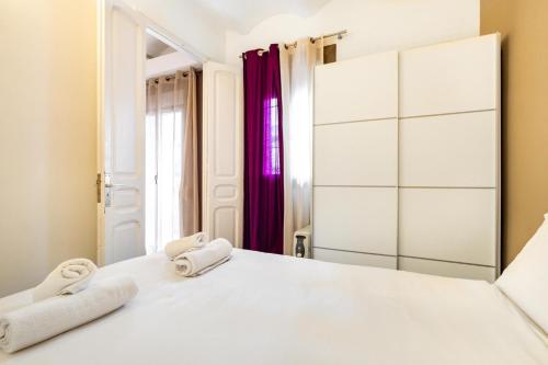 Un dormitorio con una cama blanca con toallas. en Stay U-nique Apartments Radas, en Barcelona