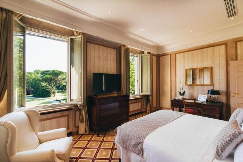 Villa Abbondanzi Resort في فاينسا: غرفة نوم بسرير ابيض وتلفزيون