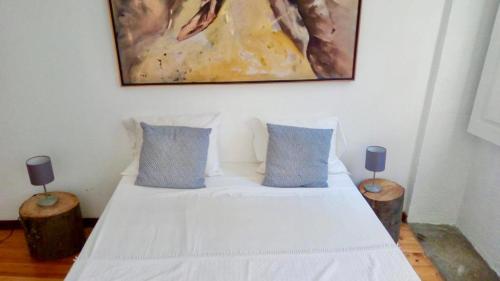 a bedroom with a white bed with two blue pillows at Historical Porto Apartment in Porto