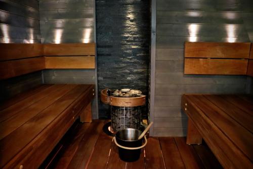 a sauna with a bucket in the middle and two benches at Hattapukki - Villa Himpula in Sysmä