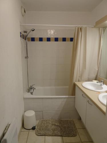 une salle de bain avec un lavabo, une baignoire et des toilettes dans l'établissement Les Manades, à Aigues-Mortes