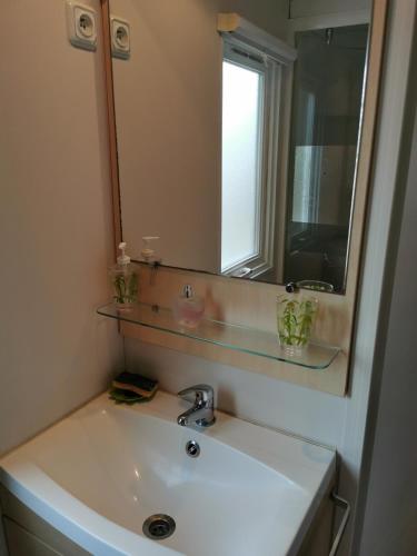 une salle de bain avec un lavabo blanc et un miroir dans l'établissement Assist' Mobil Home 276 - Mobil home 3 chambres au calme, à Onzain