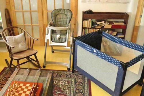 a living room with a chess table and a chair at La maison du capitaine est à vous! in Tadoussac