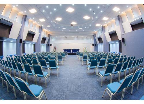 an empty room with chairs and a stage in the background at Leques Brasil Hotel Escola in Sao Paulo