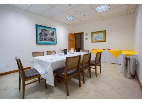 a dining room with a white table and chairs at Leques Brasil Hotel Escola in Sao Paulo