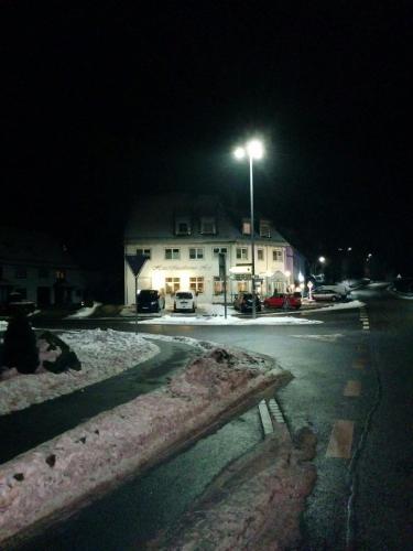 a building with a street light in the snow at night at Garni Hotel Maselheimer Hof in Maselheim
