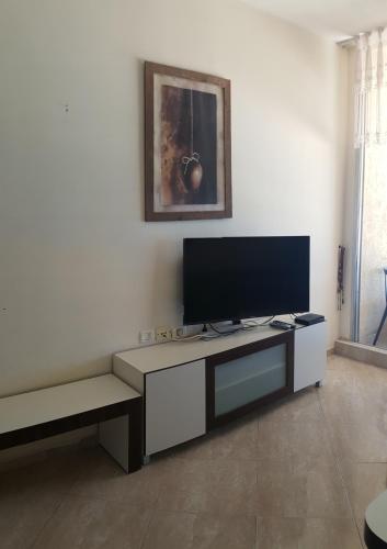 a living room with a flat screen tv on a table at Sea View Deluxe in Bat Yam