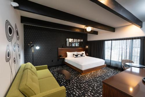 a bedroom with a bed and a couch and a desk at The Earl in Charlevoix in Charlevoix