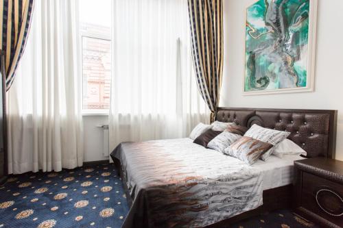 Sumskaya Apartment Lux في خاركوف: غرفة نوم بسرير ودهان على الحائط