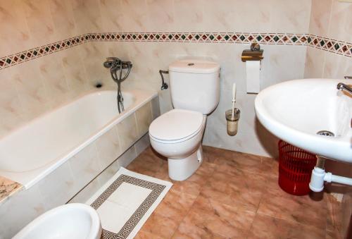 uma casa de banho com um WC, um lavatório e uma banheira em Los Dos Alemanes em Melide