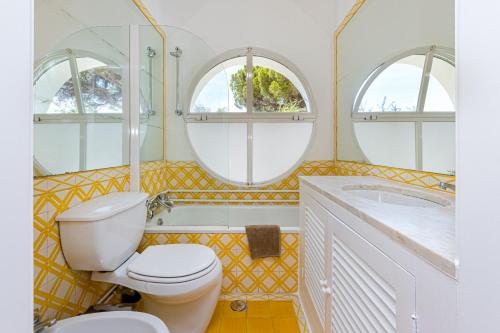 La salle de bains est pourvue de toilettes, d'une baignoire et de 2 fenêtres. dans l'établissement Villa AL Fresco, à Guia