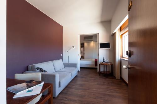 - un salon avec un canapé et une table dans l'établissement Hotel Rali Viana, à Viana do Castelo