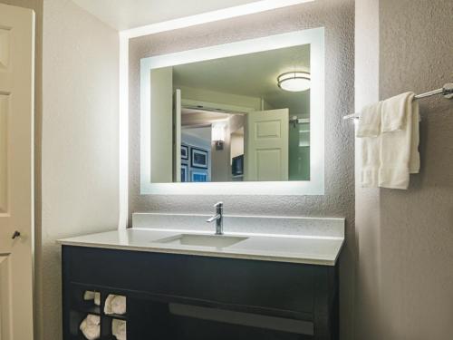 a bathroom with a sink and a mirror at La Quinta by Wyndham Oklahoma City - NW Expwy in Oklahoma City