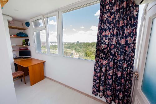 a room with a window with a desk and a curtain at Fantastic View on Chisinau Center - Super Fast WiFi - Two Botanical Gardens - 2BR in Chişinău