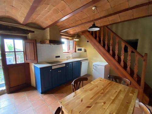 cocina con mesa de madera y escalera de madera en Can Coderch, en Ribes de Freser
