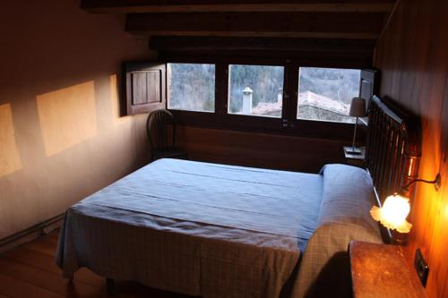 1 dormitorio con cama y ventana en Can Coderch en Ribes de Freser