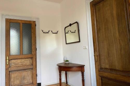 a hallway with a door and a table and a mirror at Authentic Stays - 6p-apartment in Eijsden