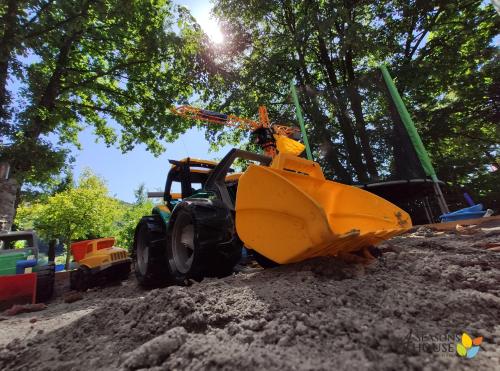 a yellow bulldozer sitting in a pile of dirt at 4 Seasons - House in Sub Cetate