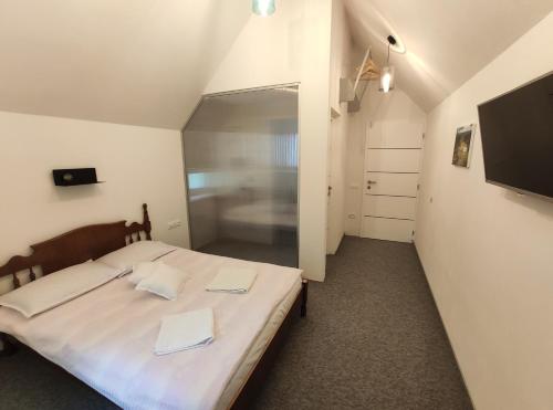 a bedroom with a bed with white sheets and a tv at 4 Seasons - House in Sub Cetate