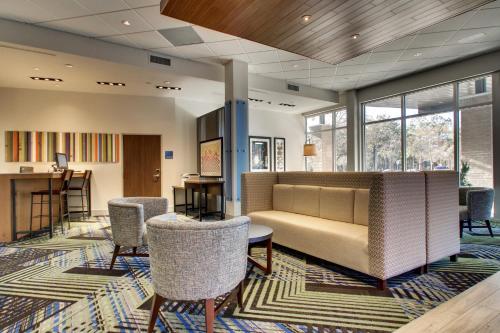 a lobby with a couch and chairs and a bar at Holiday Inn Express & Suites Charleston NE Mt Pleasant US17 by IHG in Charleston