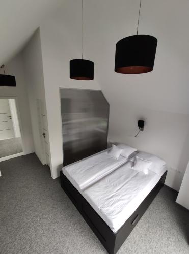 a bedroom with a bed with two pendant lights at 4 Seasons - House in Sub Cetate
