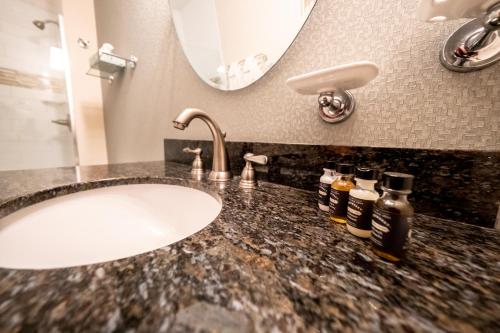 a bathroom counter with a sink and a mirror at The Inn at Shattuck - St. Mary's in Faribault