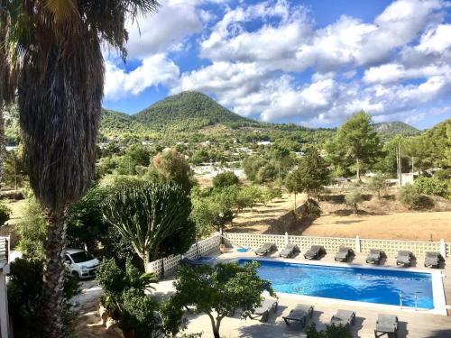 a resort with a pool and mountains in the background at Villa Alexa this charming villa is just a 10 min drive to either Playa Den Bossa or San Antonio in Sant Josep de Sa Talaia
