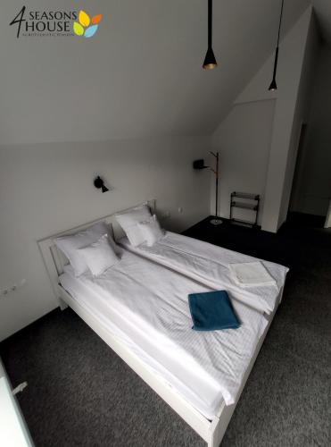 a large white bed with a blue pillow on it at 4 Seasons - House in Sub Cetate