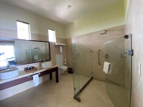 a bathroom with a shower and a sink and a toilet at Casa del Puerto by MIJ - Beachfront Hotel in Puerto Morelos
