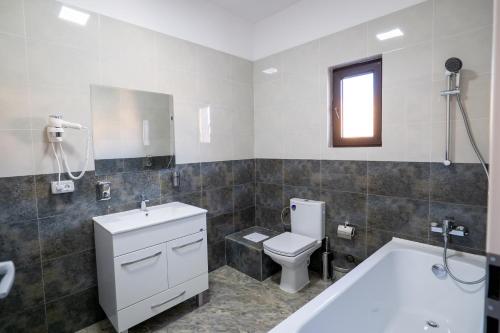 a bathroom with a tub and a toilet and a sink at Hotel Simona in Bucharest