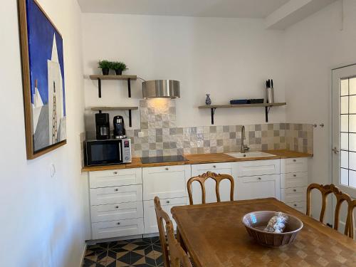 a kitchen with a table and chairs and a microwave at Authentic Stays - 6p-apartment in Eijsden