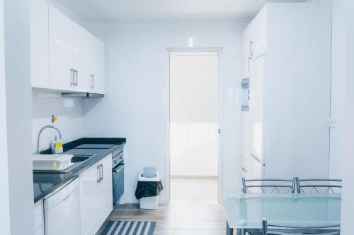 a kitchen with white cabinets and a blue sink at Dorisol Vista Formosa by rentallido in Funchal