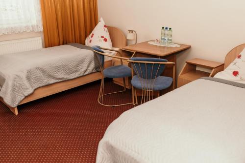 Motel Łasuch في أوسياكوف: غرفة فندقية بسرير وطاولة وكراسي