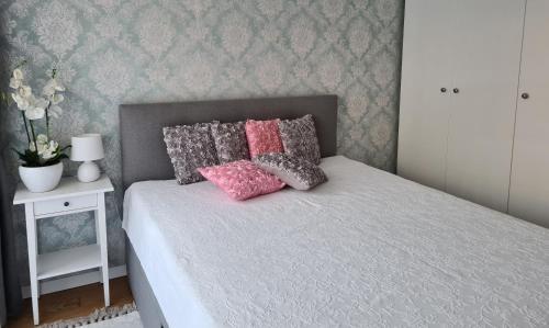 a bedroom with a bed with pink and gray pillows at Polana in Nowy Targ