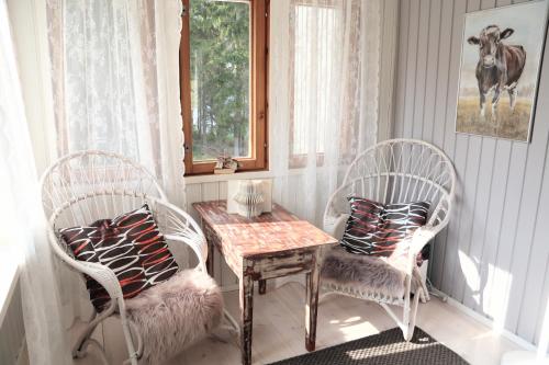 a room with two chairs and a table and a table and chairs with a table at Hattapukki - Villa Himpula in Sysmä
