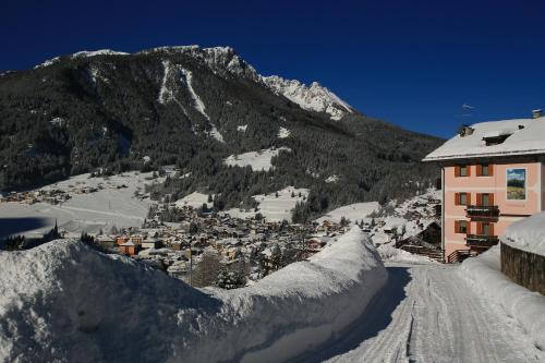 a snow covered city with a mountain in the background at Garni Miravalle in Moena