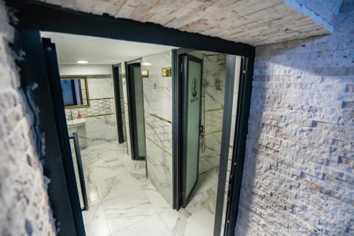 a bathroom with a walk in shower and a sink at Lion City Hotel Kizilay in Ankara