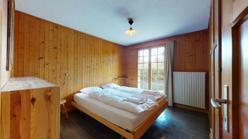 a bedroom with a bed in a wooden wall at Apartment with a breathtaking view on the 4000 Valaisan mountains in Crans-Montana