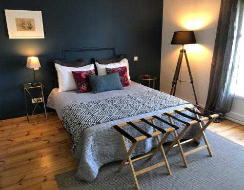 sypialnia z dużym łóżkiem z poduszkami w obiekcie La Mulonniere w mieście Saint-Sébastien-sur-Loire
