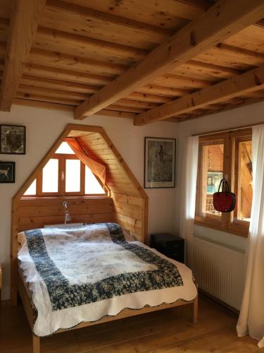 a bedroom with a bed and a large window at Valea Vinului Suite in Vişeu de Sus