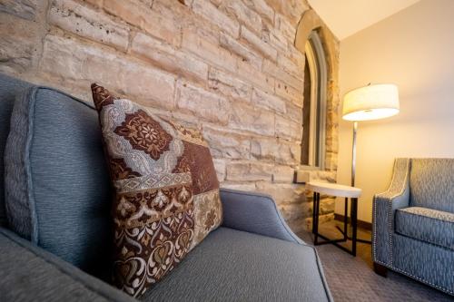 a living room with a couch and a brick wall at The Inn at Shattuck - St. Mary's in Faribault