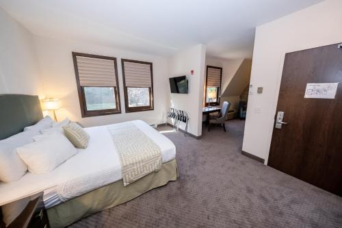 a bedroom with a large bed and a desk at The Inn at Shattuck - St. Mary's in Faribault